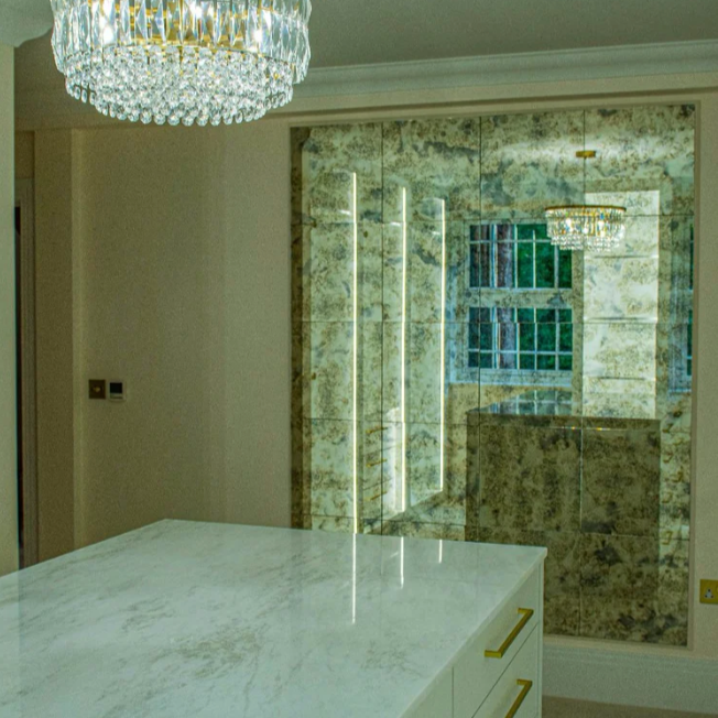 Luxurious interior with a chandelier, marble countertop, and decorative wall.