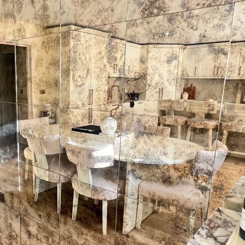 Dining area with marble-patterned wall panels and wooden floor.