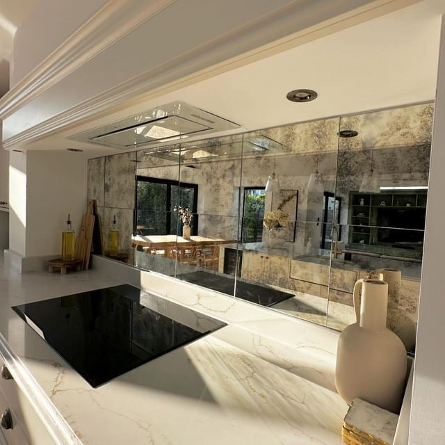 Modern kitchen with marble countertops and reflective surfaces