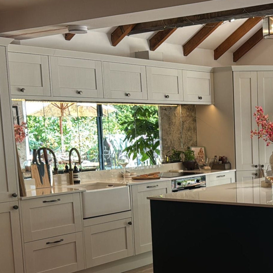 Modern kitchen with white cabinets, black island, and wooden floor.