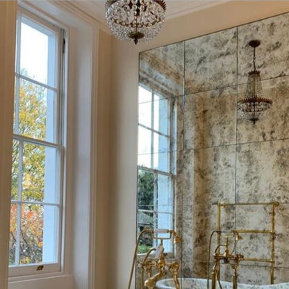 Luxurious bathroom with freestanding bathtub, gold fixtures, and large mirror.