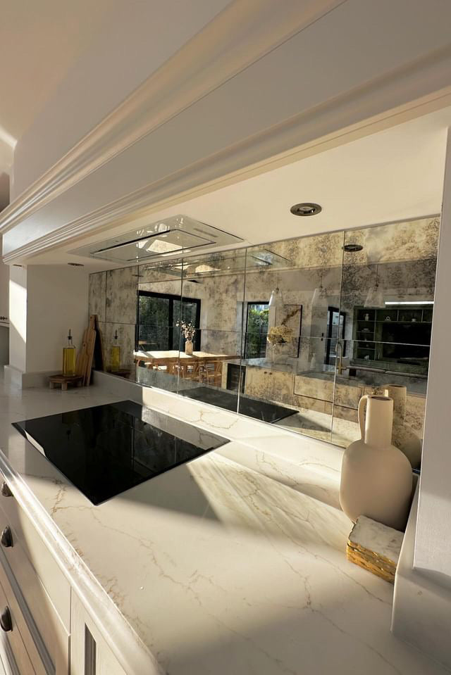 Modern kitchen with marble countertops and reflective surfaces