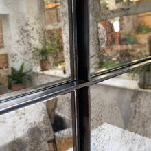 Detail of the steel cross bars and foxed glass on a four panel antique mirror