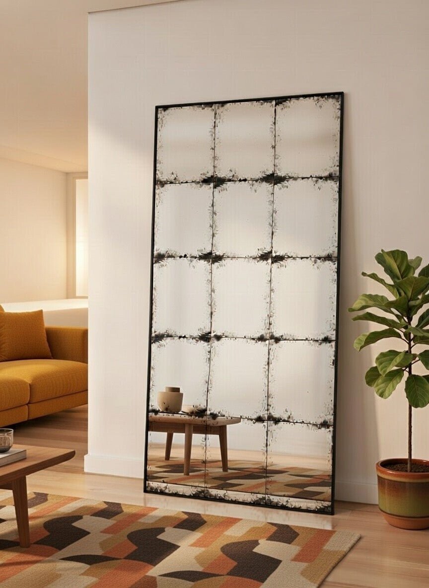 Constantine rectangular antique mirror leaning in a living room beside a mustard armchair